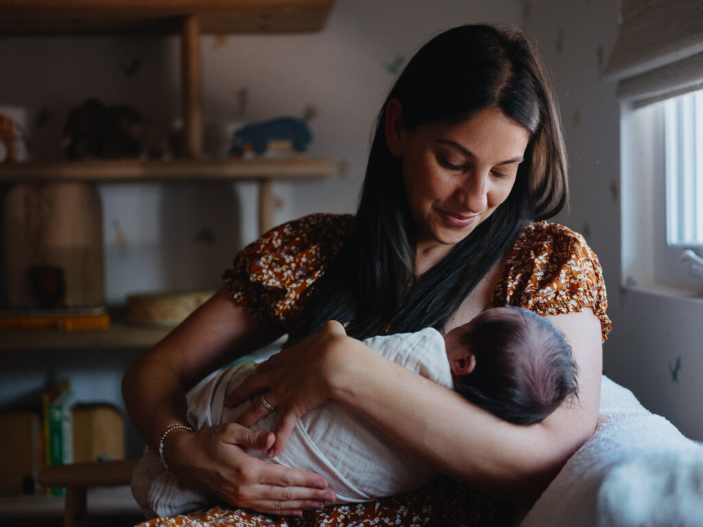 Newborn Photography Poses: Mother holds newborn baby in her arms