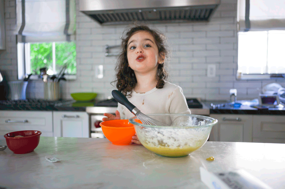 Gif of a young girl making banana bread in her kitchen serving as a great example of recipes to make with your kids. 