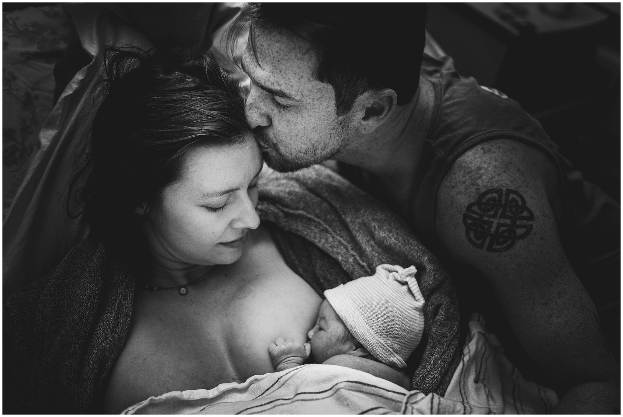 Black & white photo of a couple with their newborn baby moments after his birth