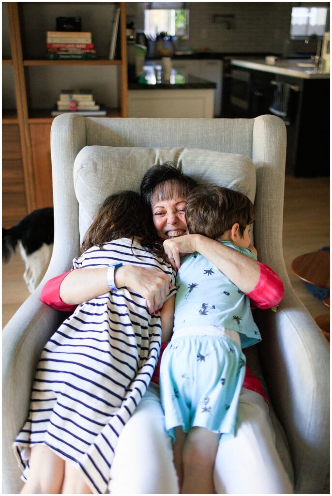 A grandmother blissfully hugging her two grandchildren. 